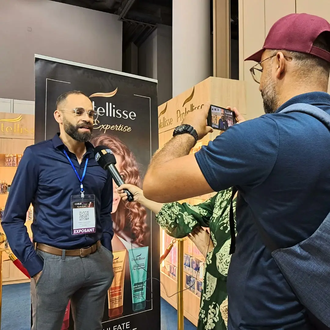 An exhibitor interviewed on camera at his stand