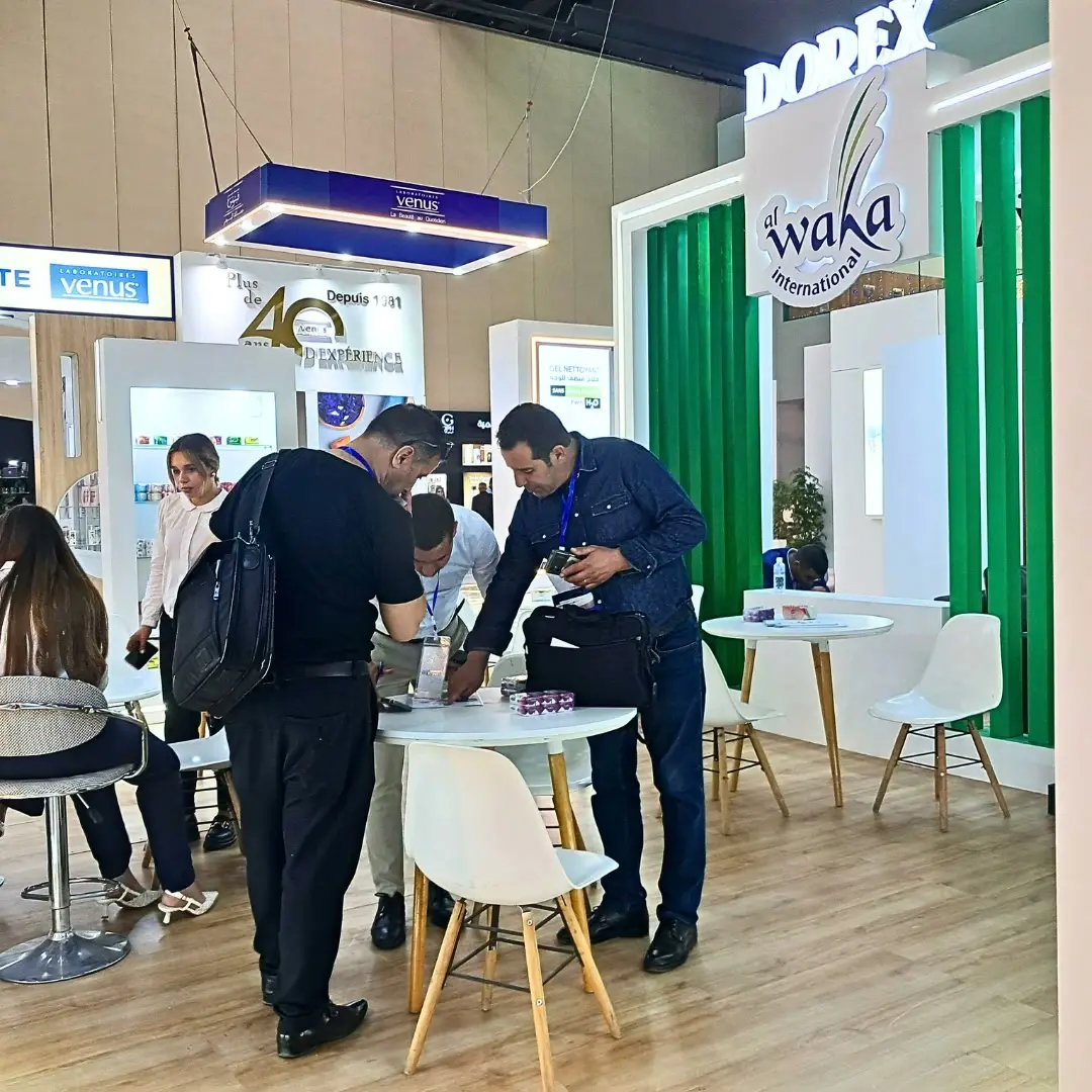 Visitors and exhibitors around the tables of a stand