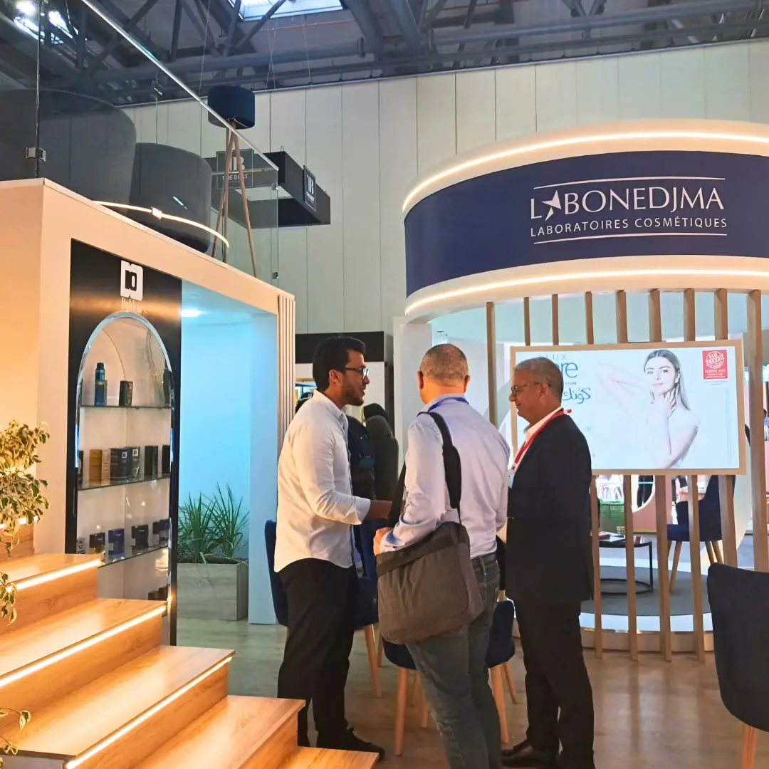 Visitors talking in front of a cosmetics laboratory's stand