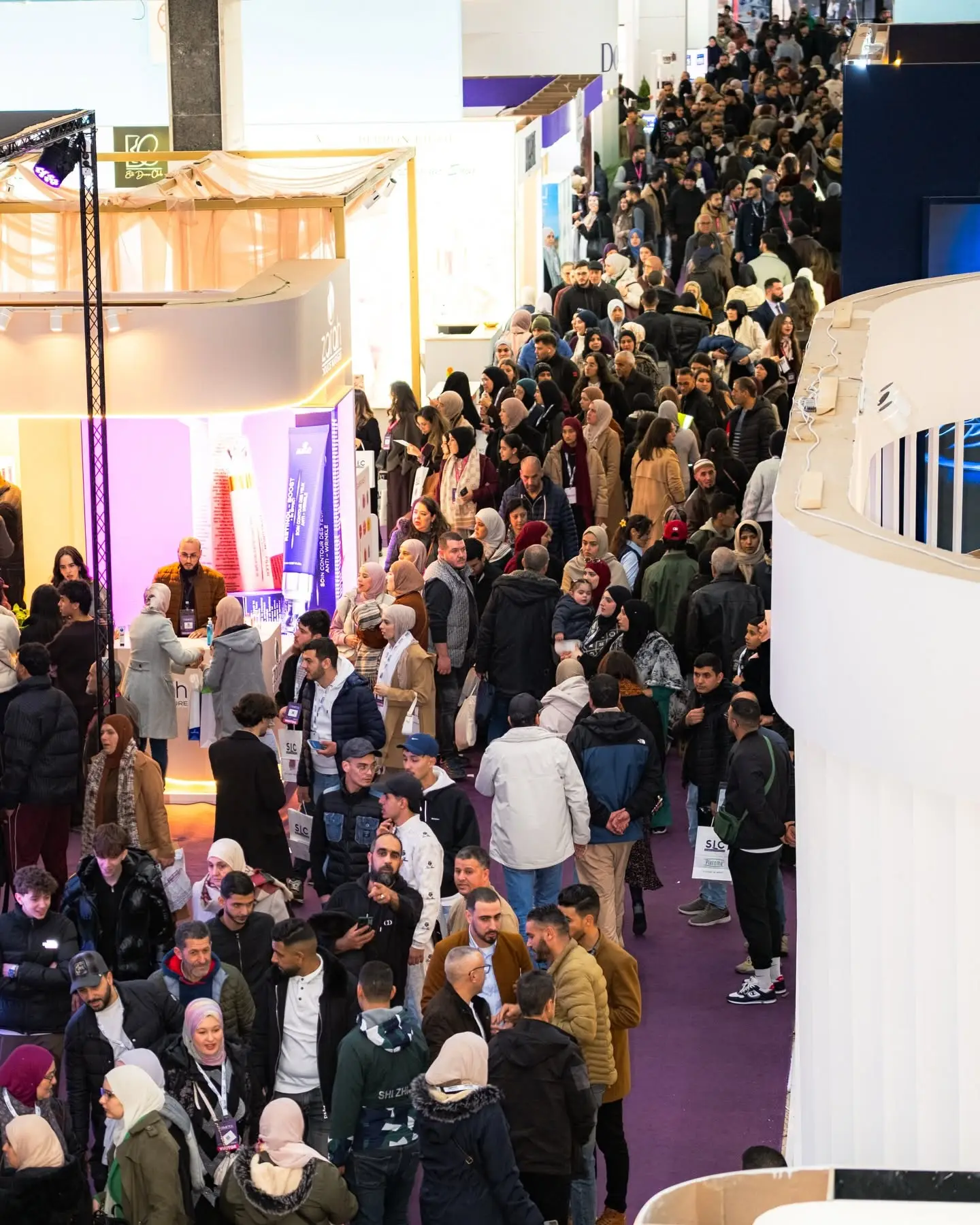 An aisle of the show full of visitors, seen from above