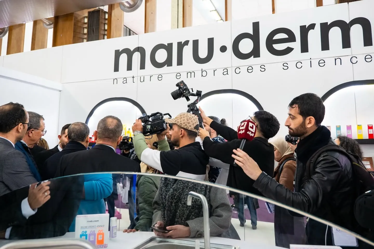 Journalists and cameras around a brand’s stand at Cosmetica Africa 2026