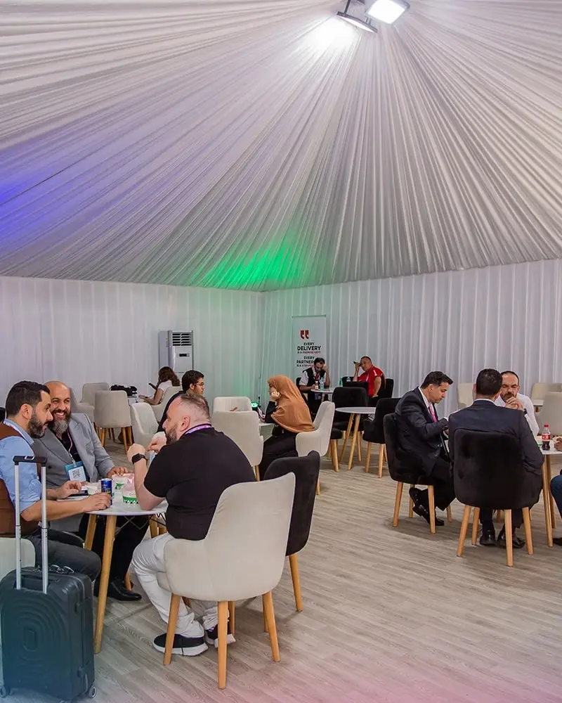 Business meetings around small tables in the show's tent
