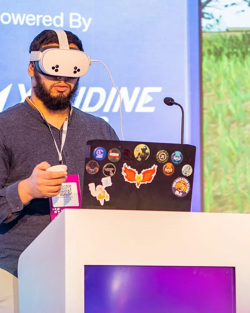 A virtual reality demonstration, headset on, at a stand's lectern